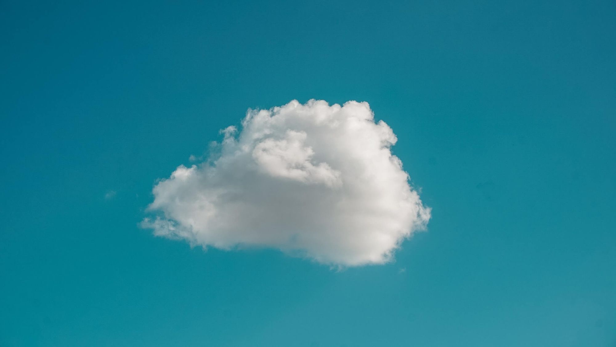 A blue sky with a single white cloud