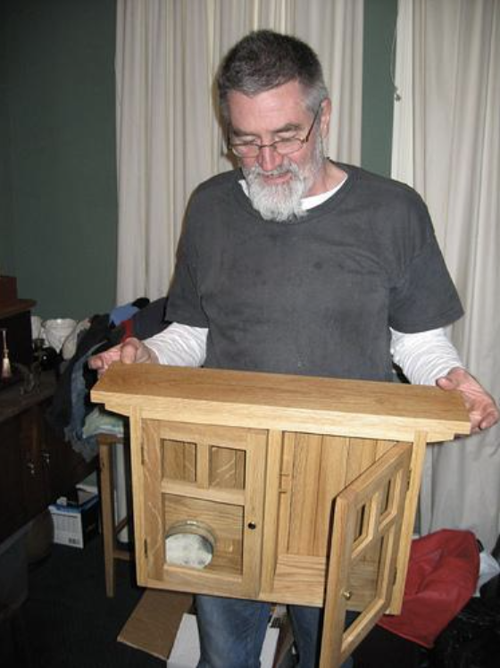 A man holding a wooden cabinet